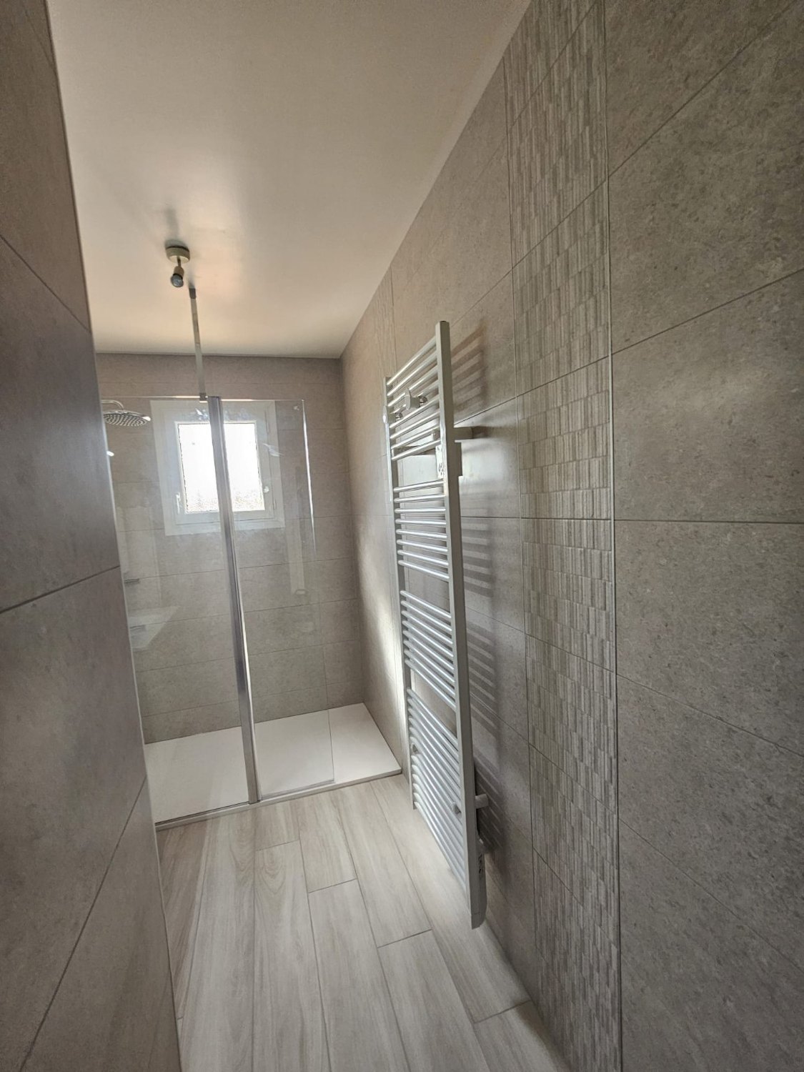 Espace douche rénové avec carrelage clair