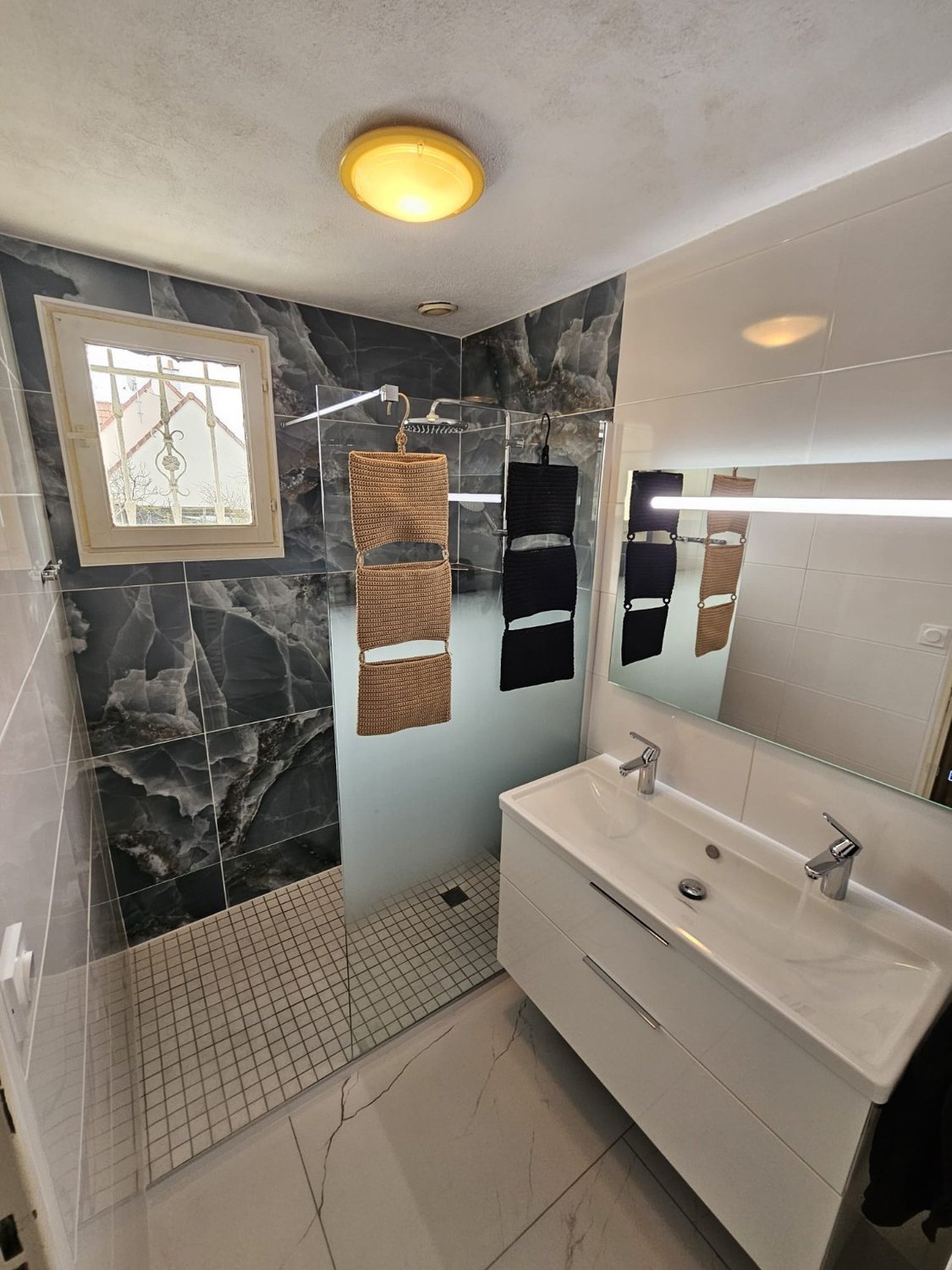 Douche rénovée avec carrelage effet marbre sombre