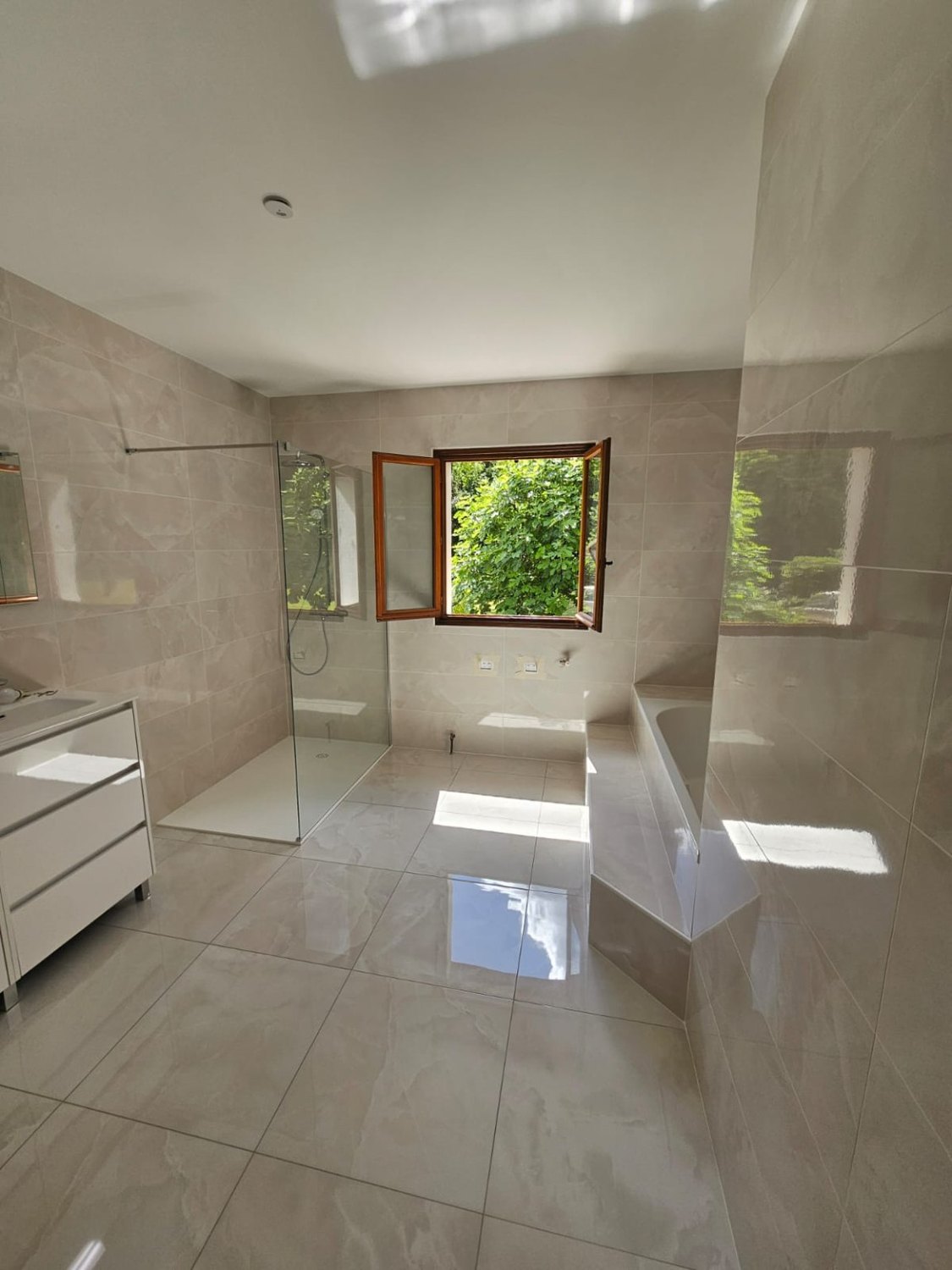 Salle de bains rénovée dans des tons beige et pierre